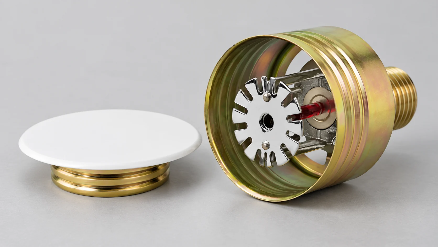 Component illustration of a concealed sprinkler cup with an intact thermal bulb and a separate cover plate.