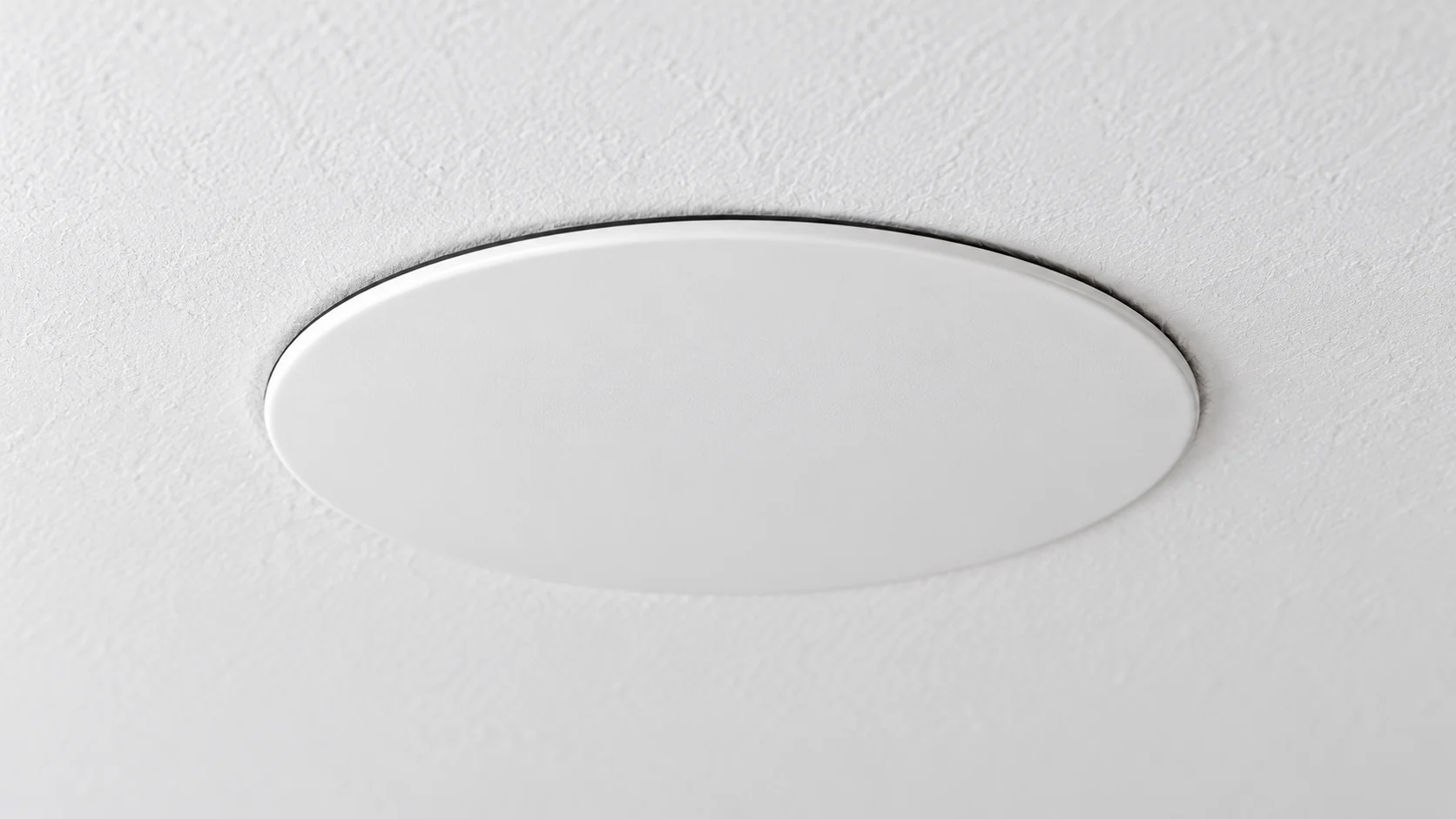 Illustration of a concealed sprinkler cover edge below a finished ceiling.